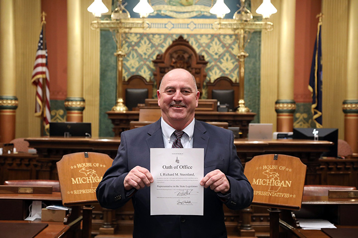 Newly-elected state Representative Richard Steenland (D-Roseville) shows off his Oath of Office after being sworn in on December 4, 2020.