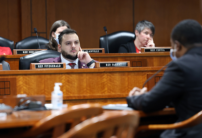 State Rep. Alabas Farhat listens to testimony in the House Health Policy Committee behind a dais.