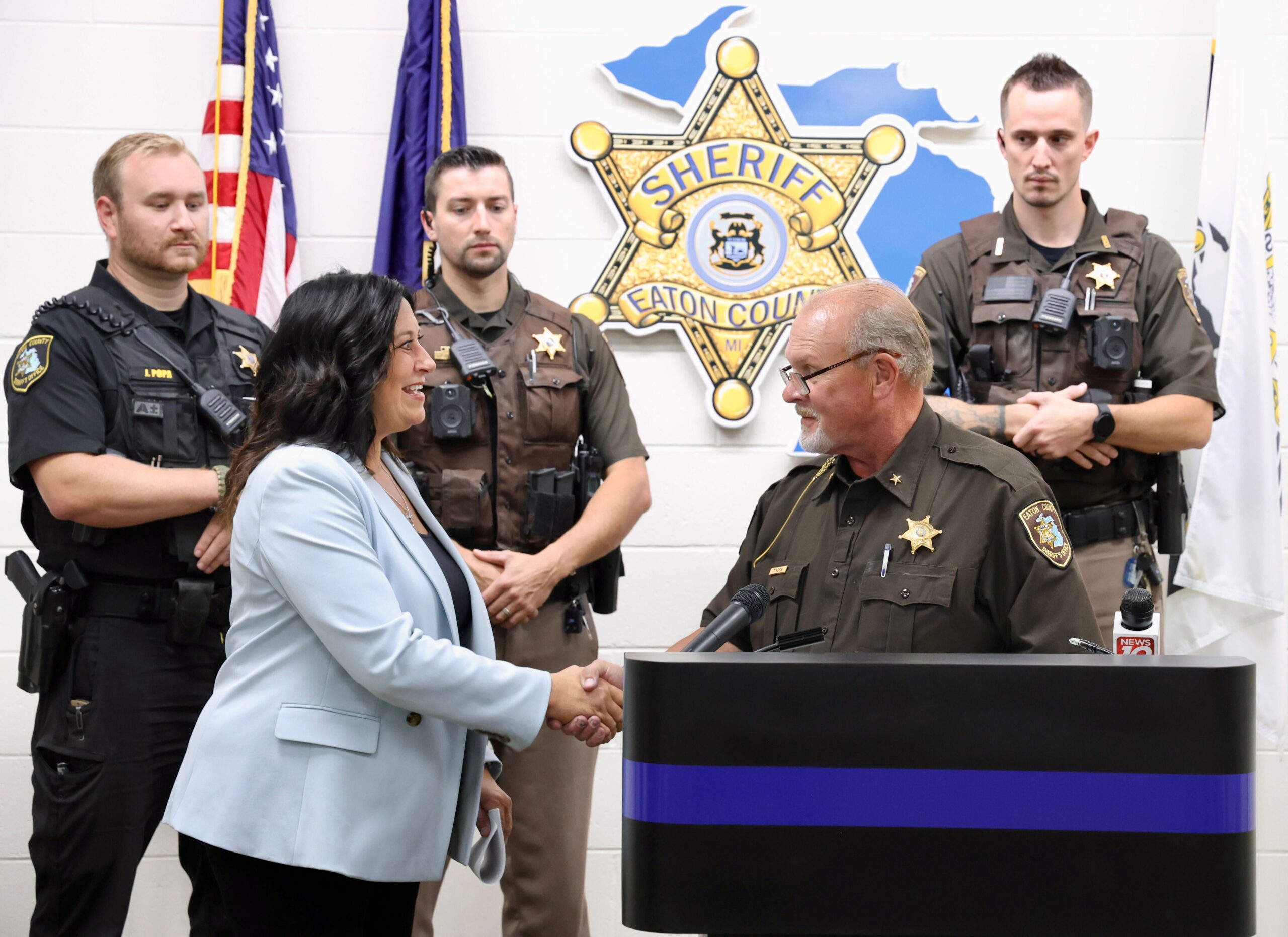 State Rep. Angela Witwer (Delta Township) shakes the hand of Eaton County Sheriff Tom Reich during a press conference to discuss investments in public safety at the Eaton County Sheriff's Office.