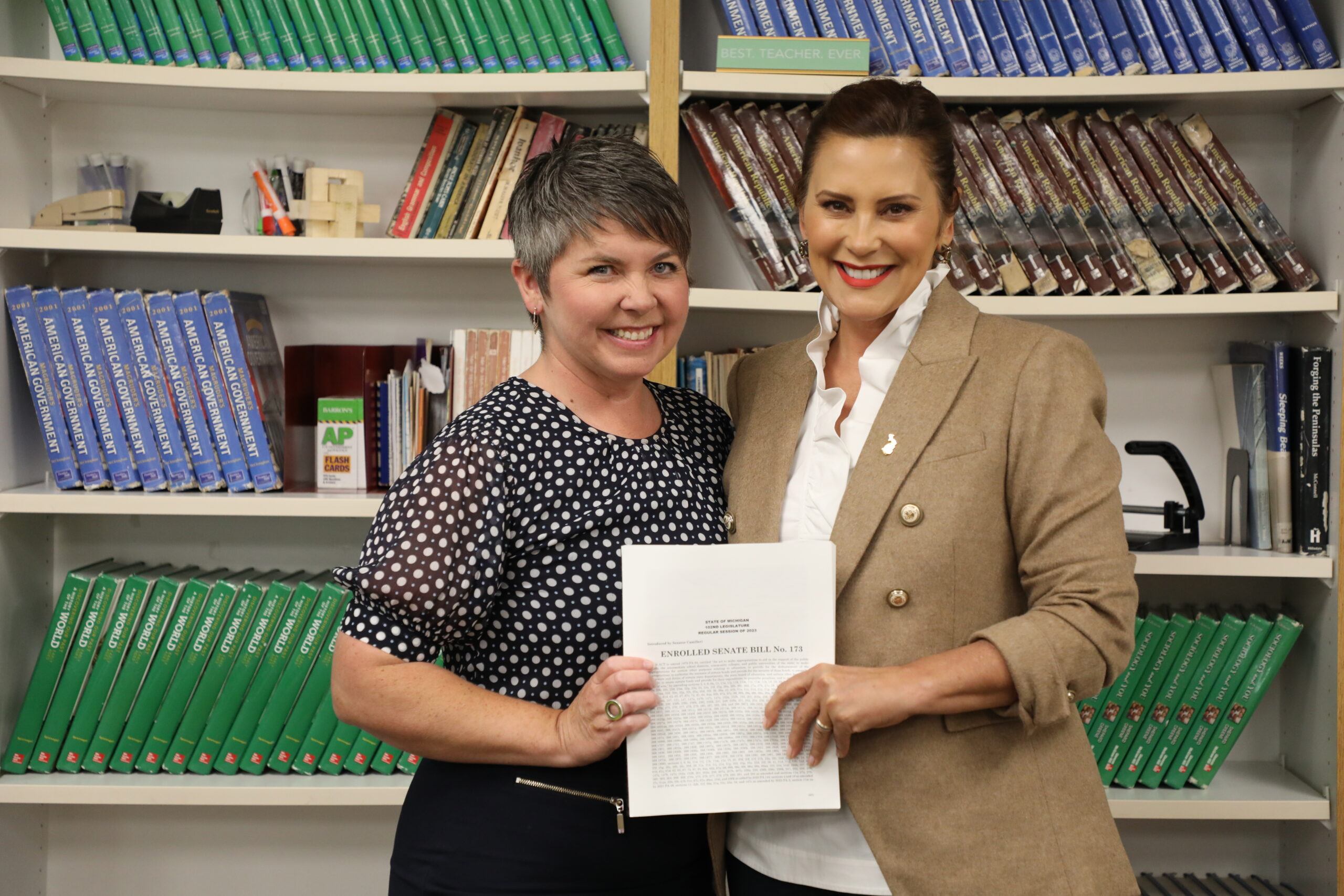 State Rep. Betsy Coffia (D-Traverse City), left, holds the 2023-24 education budget bill with Gov. Gretchen Whitmer, who signed the bill at a ceremony in Suttons Bay.