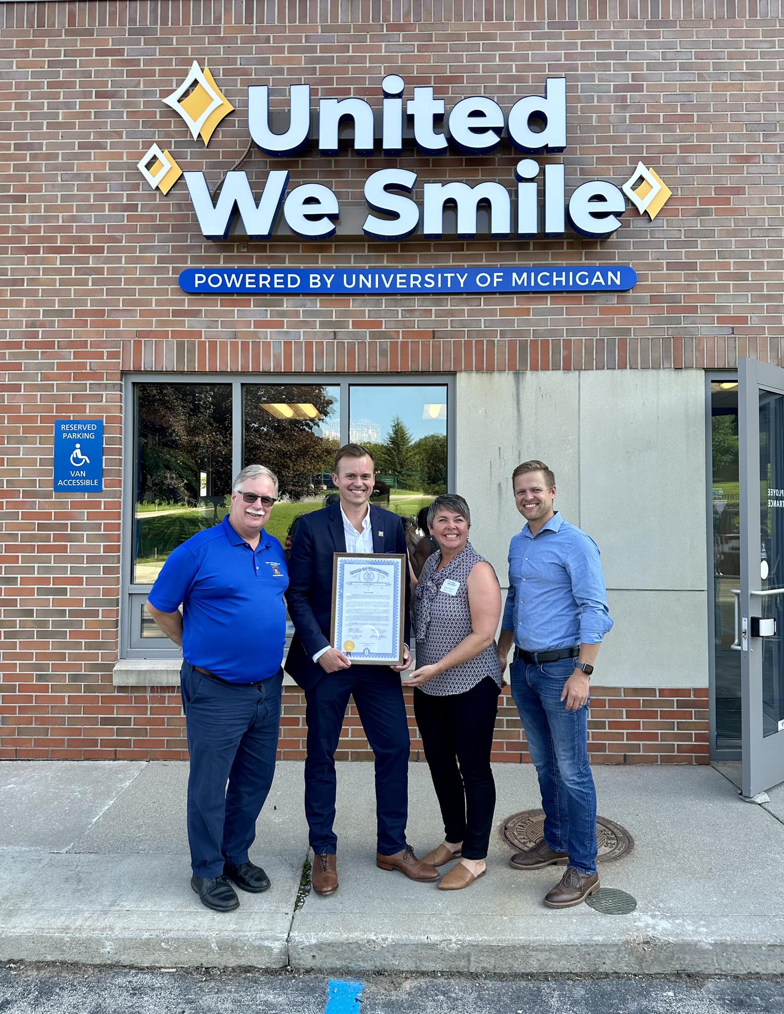 State Rep. Betsy Coffia (D-Traverse City), second from right, helped present a tribute to United Way of Northwest Michigan Executive Director Seth Johnson, second from left, on the opening of the new space for United We Smile, a clinic offering dental services to the underserved and those with special needs. 