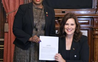 State Rep. Cynthia Neeley (D-Flint) stands next to Gov. Gretchen Whitmer after Whitmer signed House Bill 4318 into law at the Michigan State Capitol on Wednesday, Sept., 27, 2023.