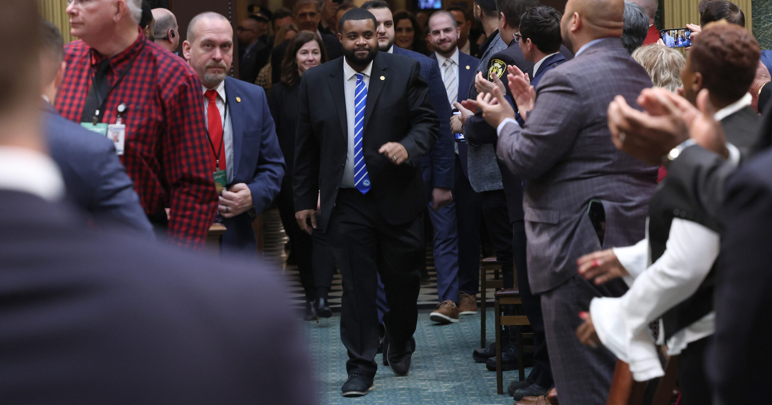 Michigan State Rep, Donavan Mckinney walks onto the house floor with applause.