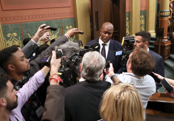 Speaker of the House Joe Tate (D-Detroit) talks with reporters on the floor of Michigan House. 
