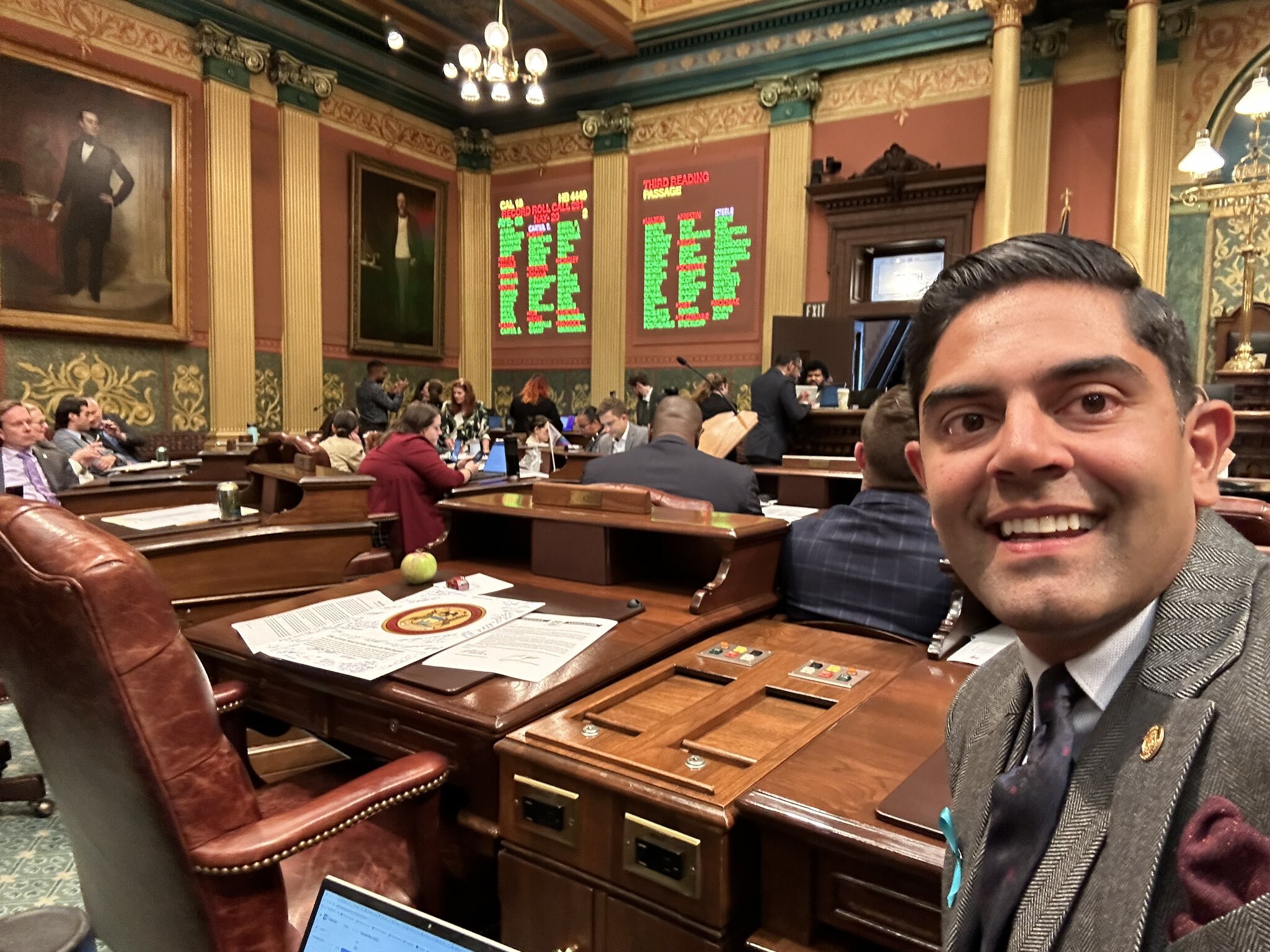 Rep. Puri takes a selfie in front of the voting board showing his vote on adding holidays to the Michigan calendar has passed on the Michigan House floor.