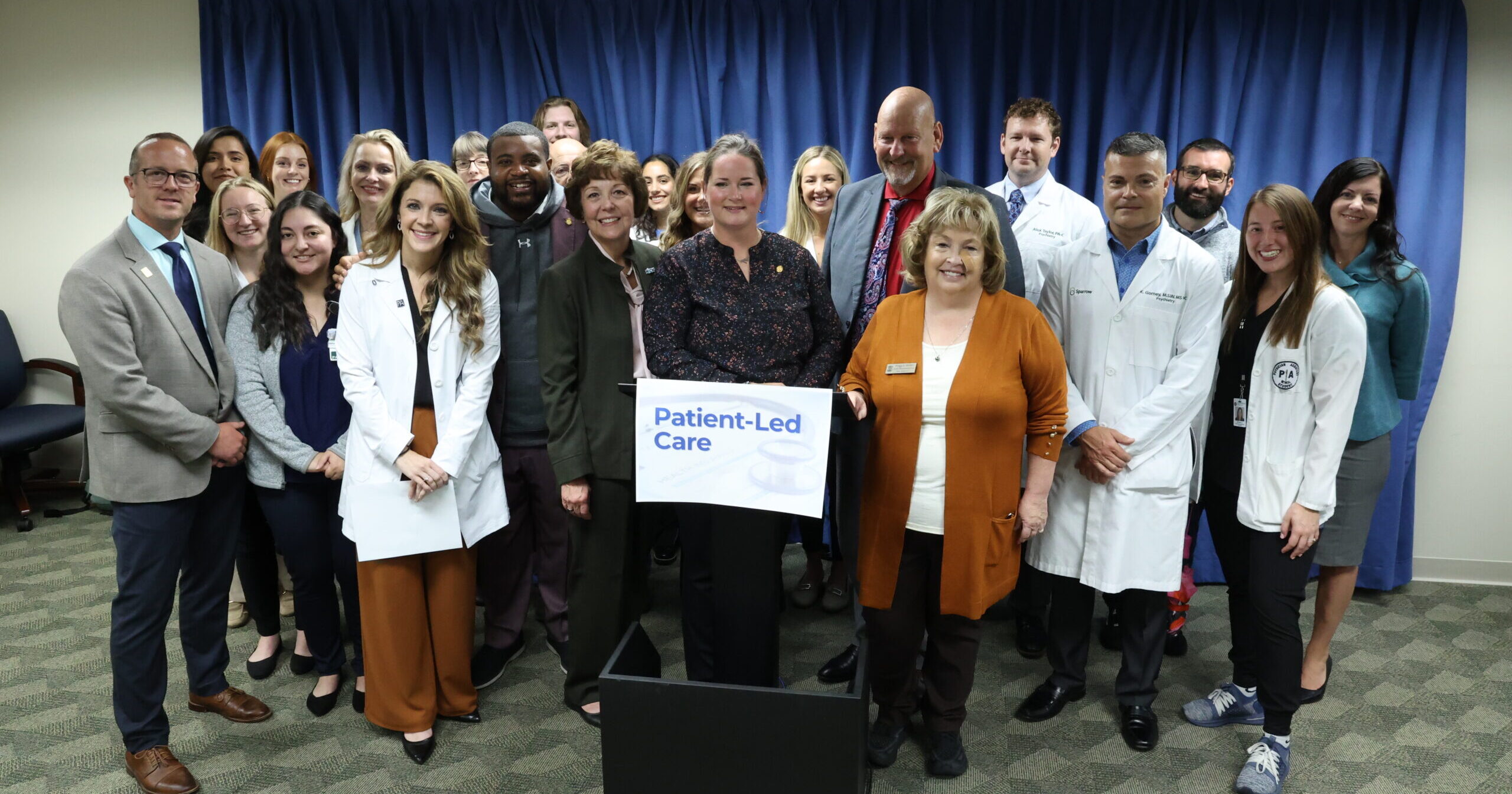 State Reps. Carrie Rheingans (D-Ann Arbor), Donavan McKinney (D-Detroit), Reggie Miller (D-Van Buren Township) and Curt VanderWall (R-Ludington), along with health care workers and students, stand together after the Patient-Led Care press conference at the House Office Building on Oct. 5, 2023.