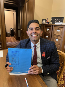 Rep. Puri holds a blueback draft of a bill while sitting in the Michigan capitol.