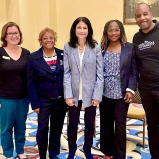 Rep. Price poses for a photo with Attorney General Dana Nessel and advocates. 