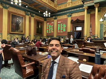 Rep. Puri takes a selfie in front of the voting board showing his bill to require water filtration systems in schools and child care centers has passed on the Michigan House floor.