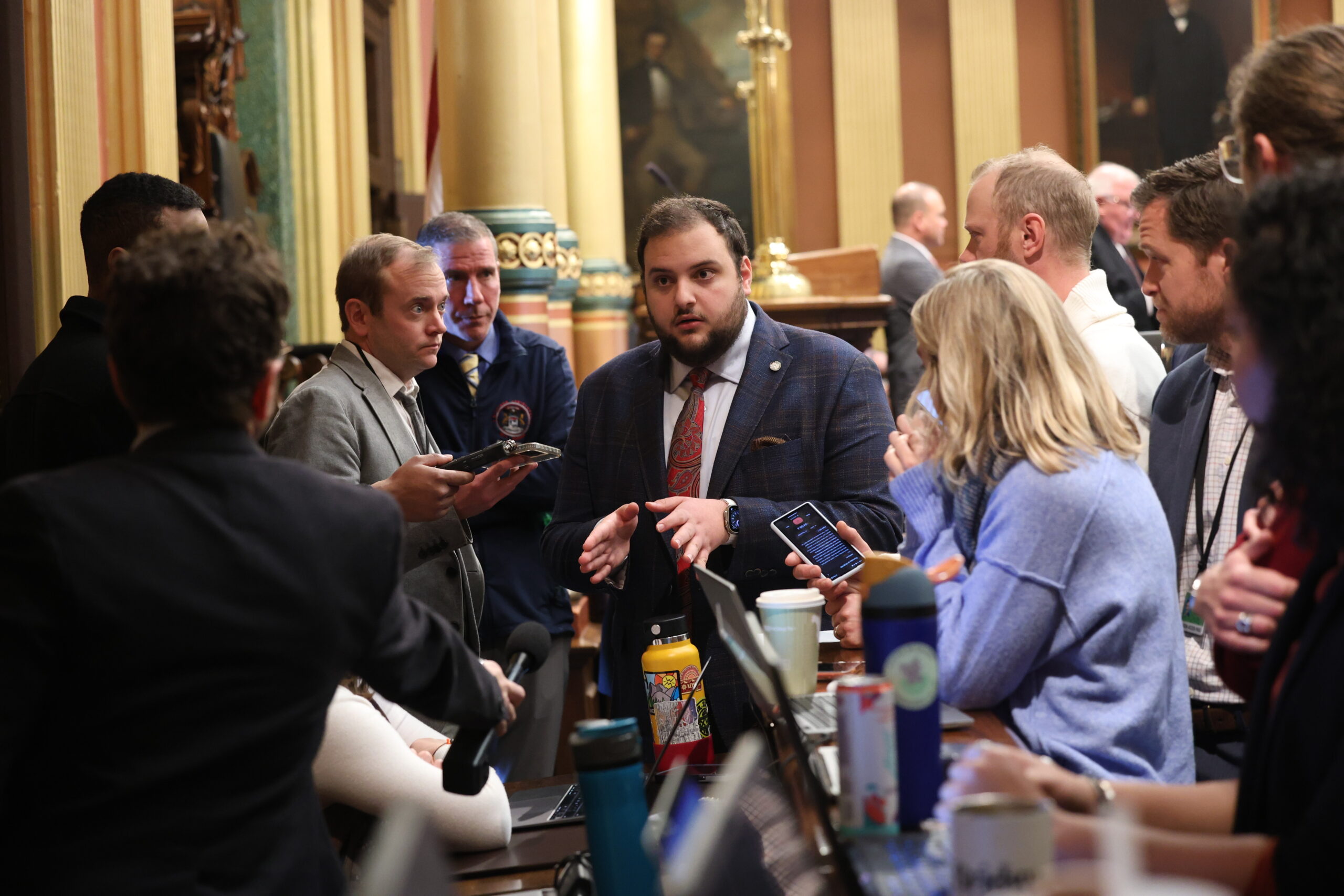 Rep. Alabas Farhat speaks with reporters in the front of the Michigan House of Representatives as Rep. Nate Shannon looks on.