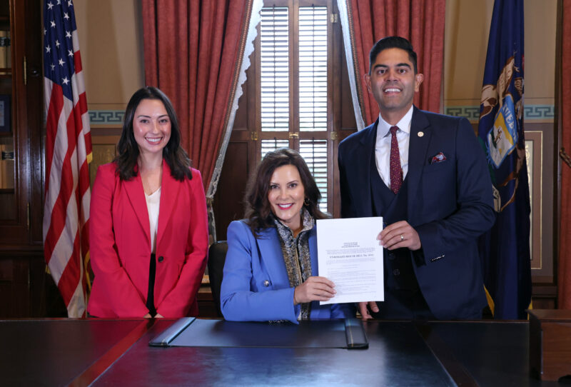 With Legislative Director Hannah Chapman, Rep. Ranjeev Puri and Gov. Whitmer hold Rep. Puri's public act in the Michigan capitol.