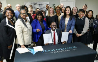 Lt. Gov. Garlin Gilchrist II holds a bipartisan bill package yesterday while surrounded by Michigan legislators and stakeholders.