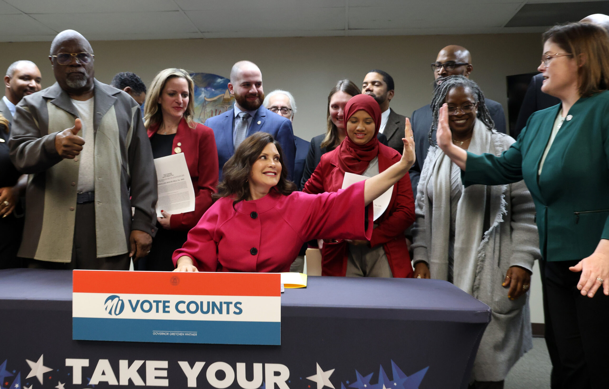 State Rep. Kara Hope (D-Holt), right, high-fives Gov. Gretchen Whitmer during a bill-signing ceremony on Nov. 30, 2023, at the ACLU in Detroit. 