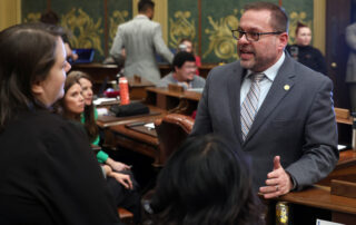 Rep. McFall speaks with colleagues on the Michigan House of Representatives floor.