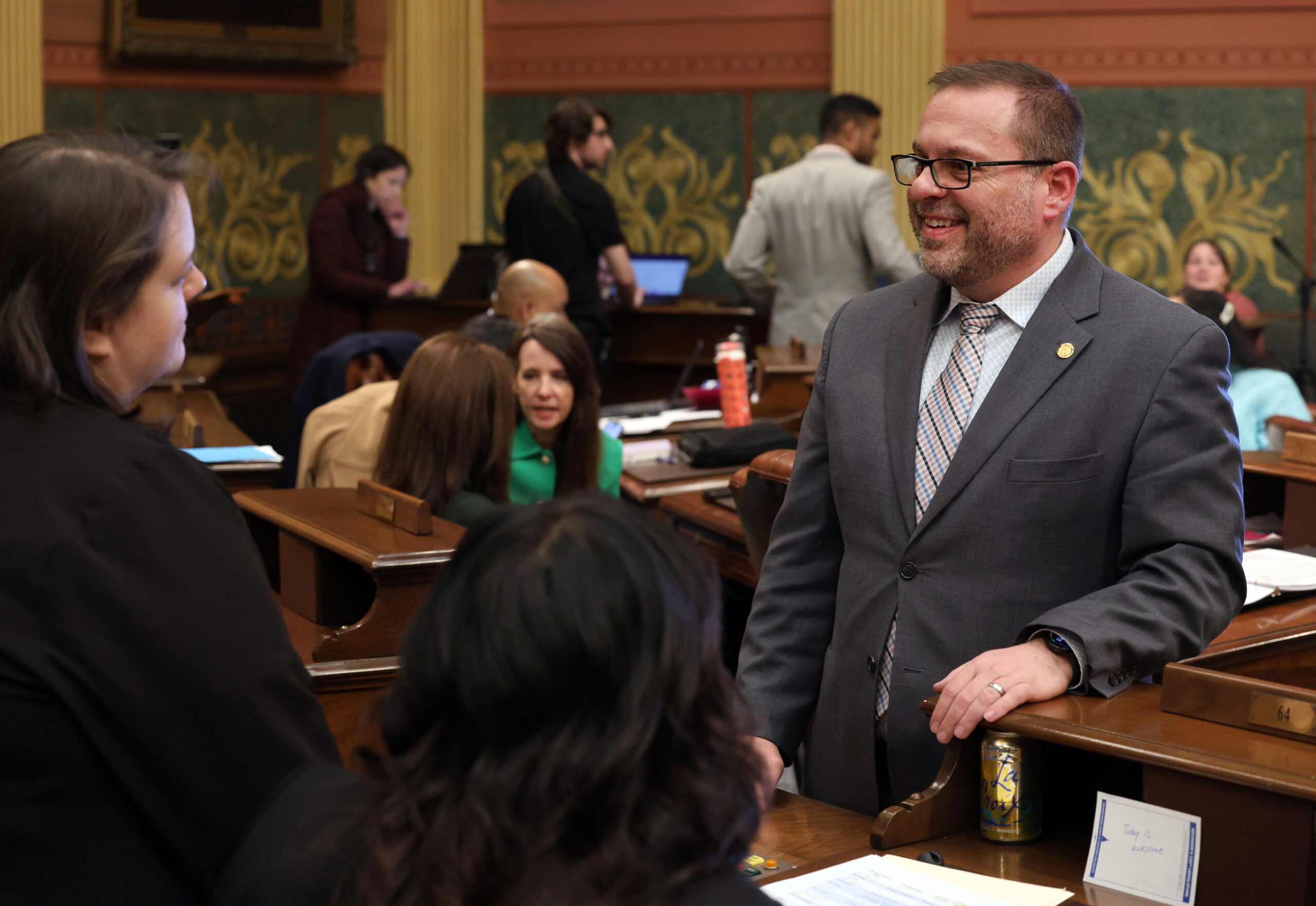 Rep. Mike McFall speaks with colleagues on the Michigan House floor.