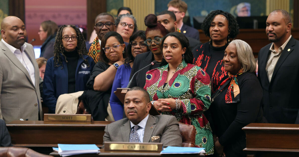 Members of the House Democratic Caucus and Michigan Legislative Black Caucus gather around state Rep. Kristian Grant (D-Grand Rapids) as she speaks in support of a resolution to celebrate Black History Month on Feb. 28, 2024, at the state Capitol in Lansing.