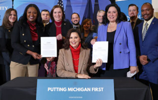 Lawmakers pose at a bill signing on Monday, Dec. 18, 2023, at Grand Valley State University in Grand Rapids.