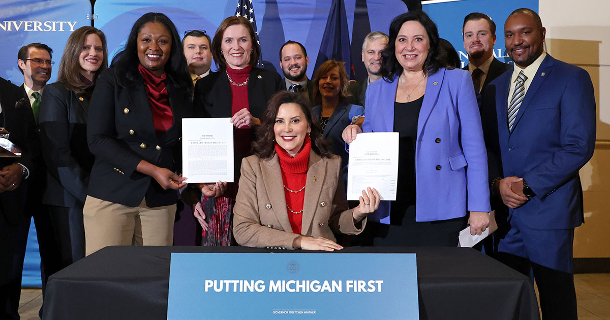 Lawmakers pose at a bill signing on Monday, Dec. 18, 2023, at Grand Valley State University in Grand Rapids.