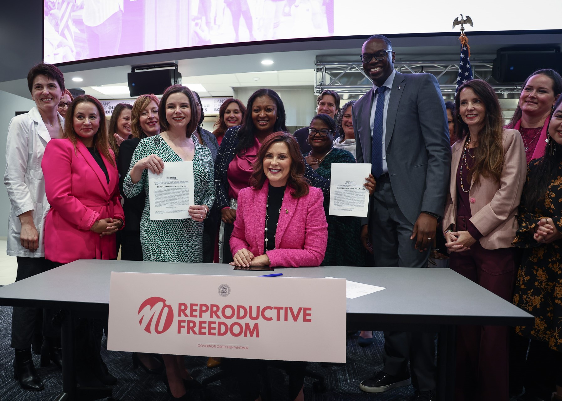 Michigan lawmakers pose with Gov. Whitmer for a photo at the Reproductive Health Act bill signing.
