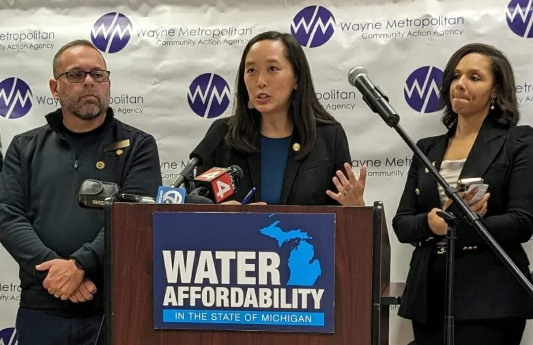 Rep. McFall and Detroit City Council President Mary Sheffield flank State Sen. Stephanie Chang speaking at a podium with a sign that reads, "Water affordability in the State of Michigan."