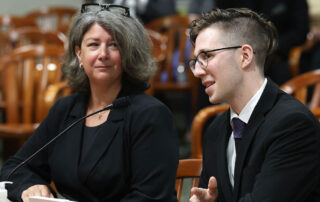 Alex Bowerson (right), cardiac survivor and heart safe schools advocate, speaks in support of the bills on March 5, 2024 during a House Committee on Regulatory Reform hearing in Lansing.