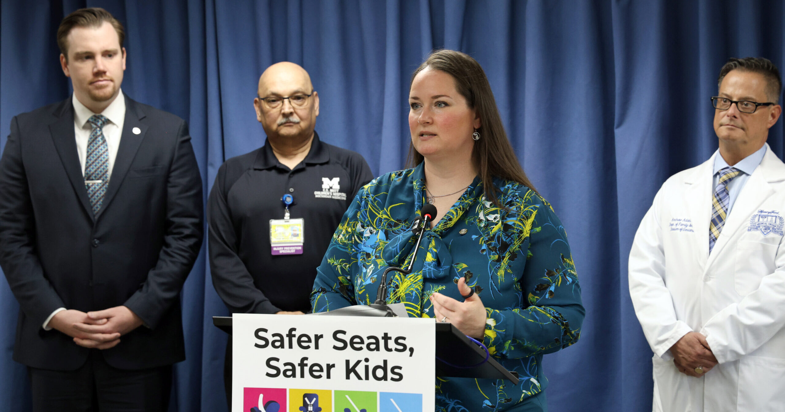 Michigan State Representitve speaks during a Safer Seats, Safer kids press conference. Surrounded by bill supporters.