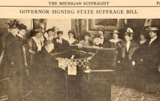 Former Michigan Gov. Albert E. Sleeper signs the states suffrage bill surrounded by suffragists on June 10, 1919.