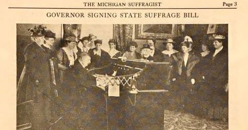 Former Michigan Gov. Albert E. Sleeper signs the states suffrage bill surrounded by suffragists on June 10, 1919.