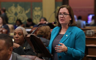 Rep. Natalie Price addresses the Michigan House from a podium on the floor.