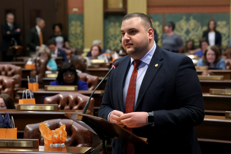Rep. Alabas Farhat speaks at a podium on the Michigan House floor.