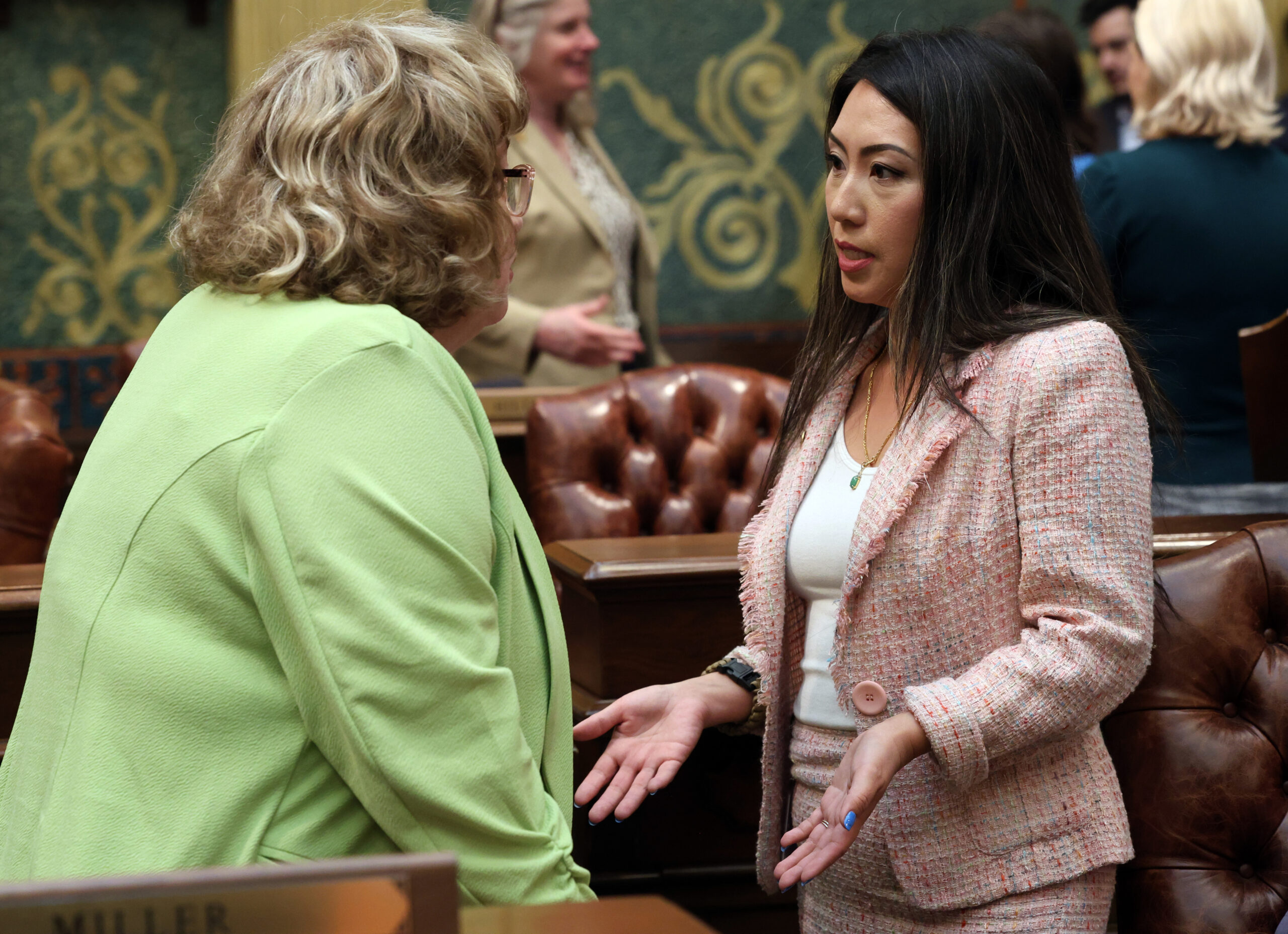 Michigan state Representative Mai Xiong speaks with a fellow legislator on the House Floor in the Michigan Capitol Building.