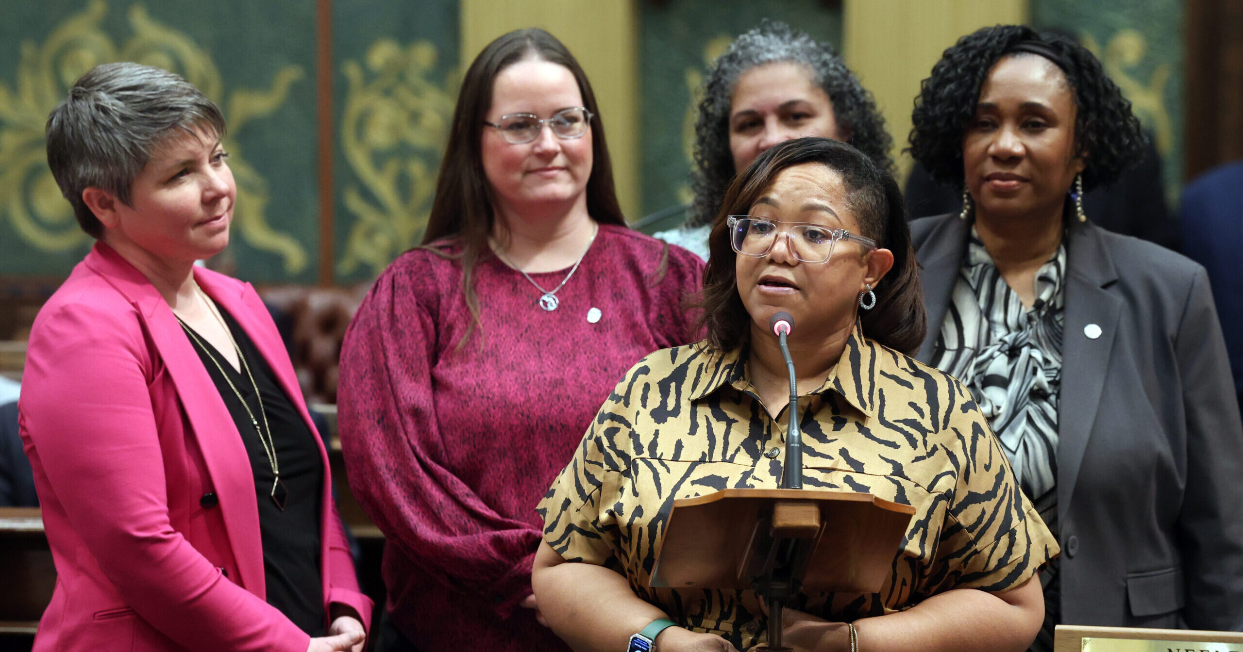 Rep. Edwards speaking on House floor while standing with Reps. Stephanie A. Young (D-Detroit), Felicia Brabec (D-Pittsfield Township), Carrie A. Rheingans (D-Ann Arbor) and Betsy Coffia (D-Traverse City).