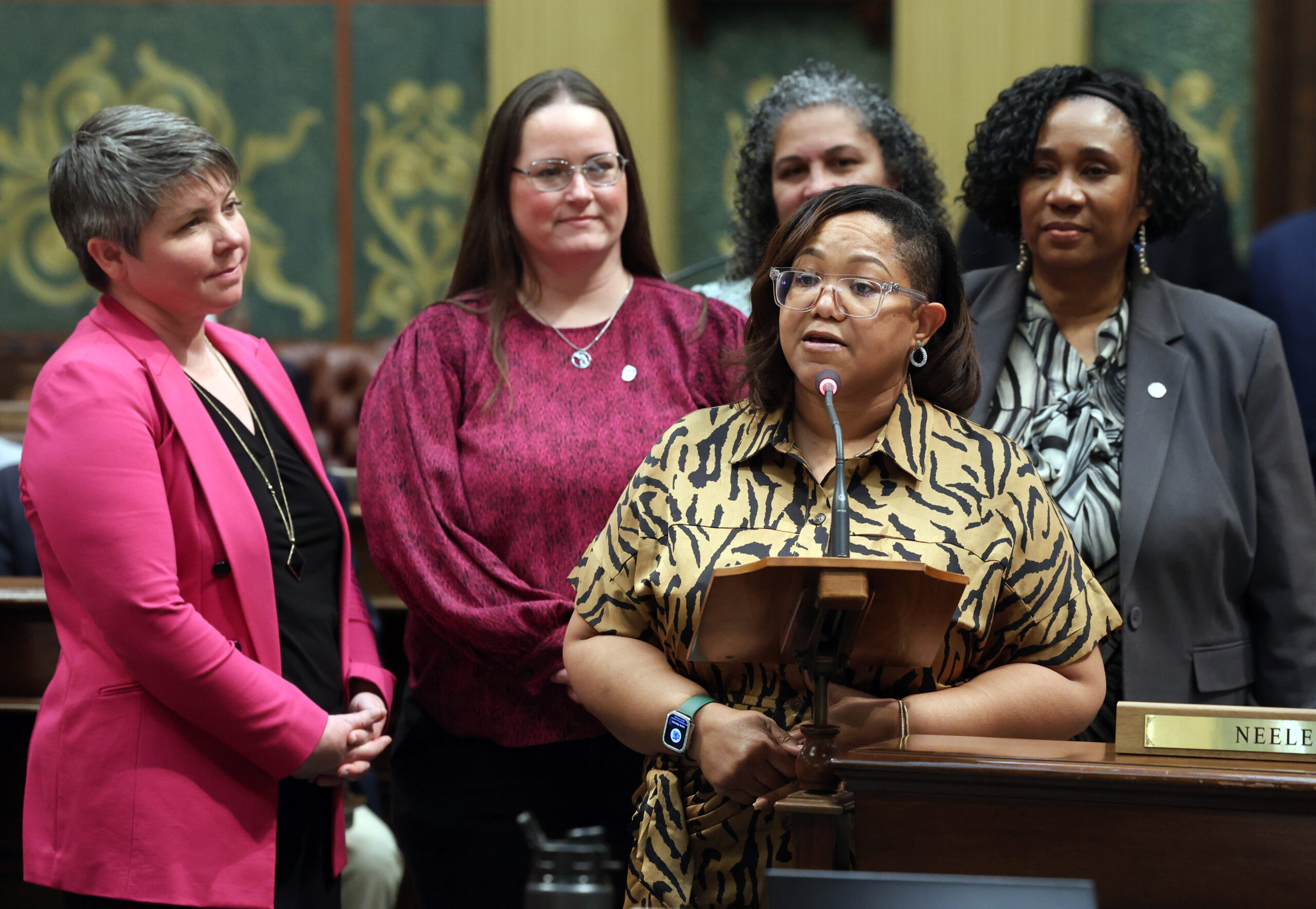Rep. Edwards speaking on House floor while standing with Reps. Stephanie A. Young (D-Detroit), Felicia Brabec (D-Pittsfield Township), Carrie A. Rheingans (D-Ann Arbor) and Betsy Coffia (D-Traverse City).