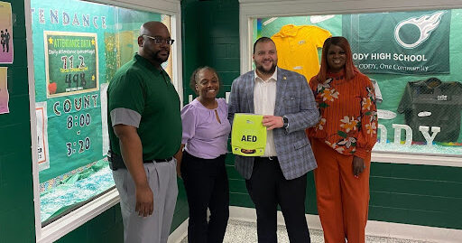 State Rep. Alabas Farhat delivering an automated external defibrillator (AED) to Cody High School.