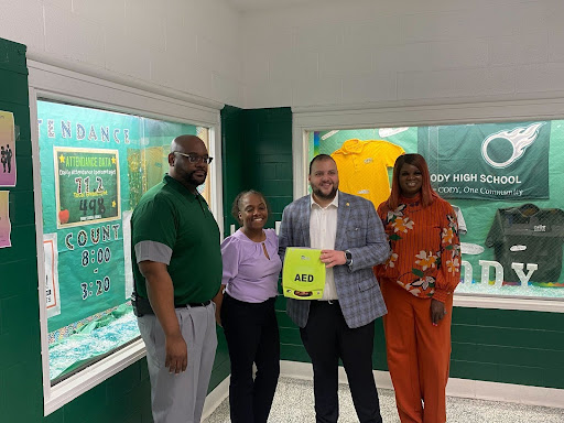 State Rep. Alabas Farhat delivering an automated external defibrillator (AED) to Cody High School.
