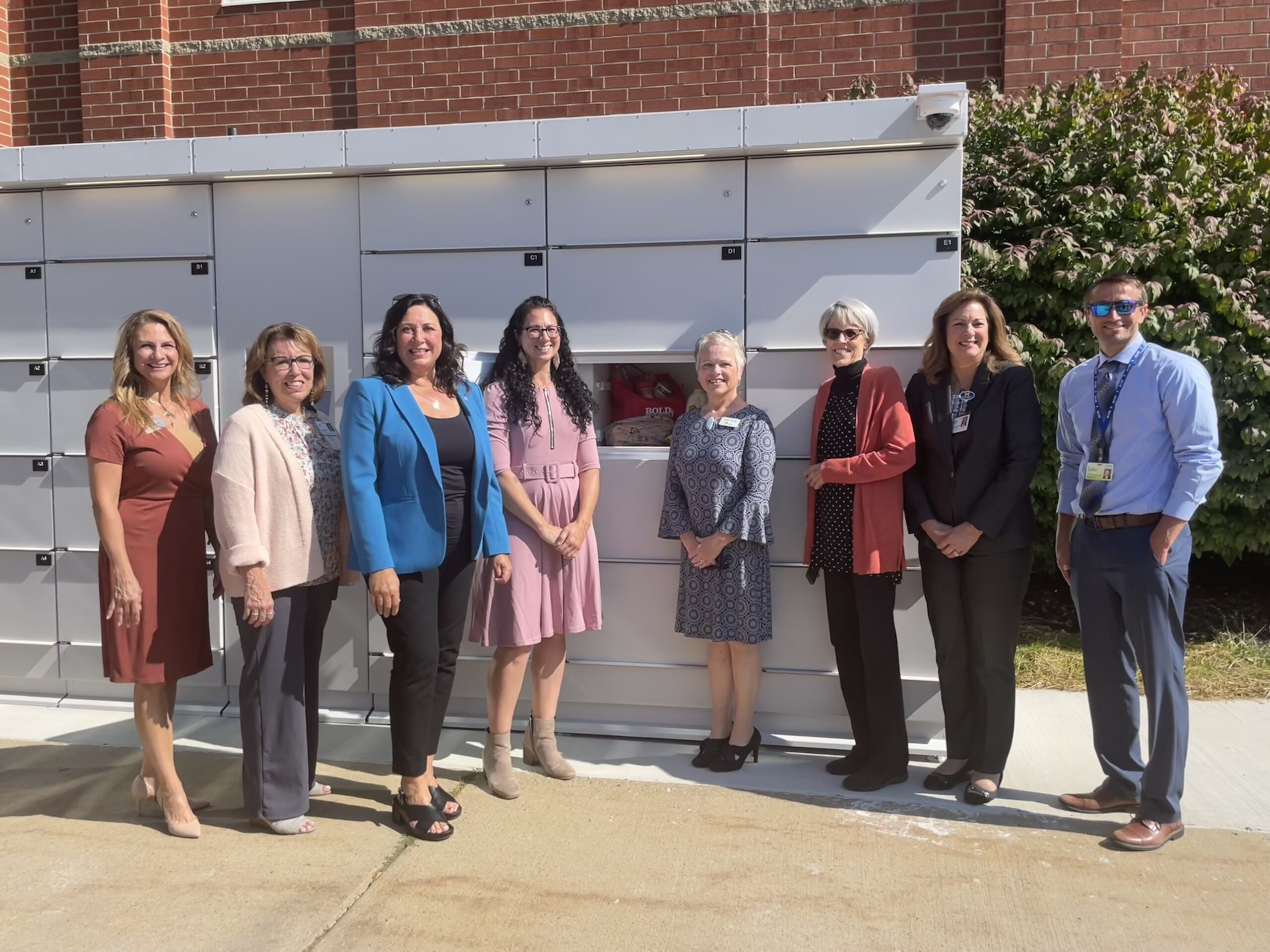 State Representative Angela Witwer stands with community officials in front of Michigan's first smart food lockers in Eaton County.