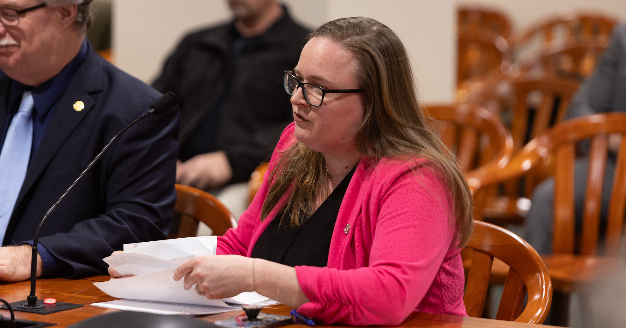 Michigan State Representative Kelly Breen testifies in a committee next to an individual.