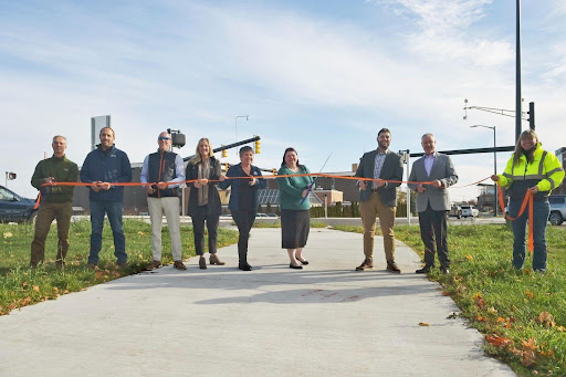 Michigan State Representative Betsy Coffia cutting the ribbon along with Traverse City Mayor Amy Shamroe and other local leaders.