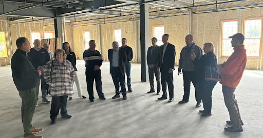 Michigan State Rep. Reggie Miller and local community members all stand in the vacant house development during a tour. building.  