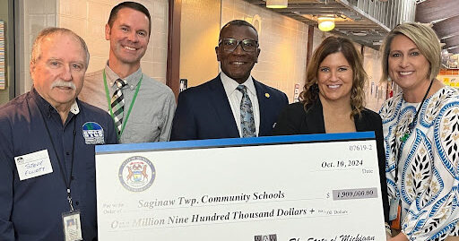 From left, Steve Elloitt, director of community services, Tom Middlin, assistant principal, state Rep. Amos O’Neal Michelle Sprague, principal and Jamie Kraatz, superintendent all smile while holding a large check, representing the secured investments for Sherwood Pool