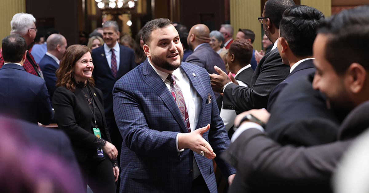 State Representative Alabas Farhat holding out hand and talking