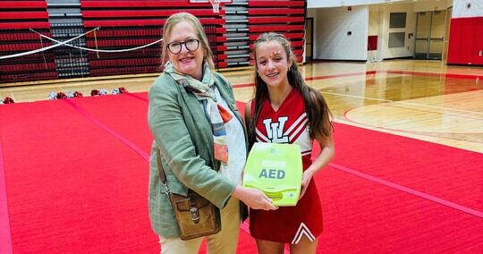 State Rep. Jennifer Conlin delivering an automated external defibrillator to Whitmore Lake High School before the fall Homecoming football game.