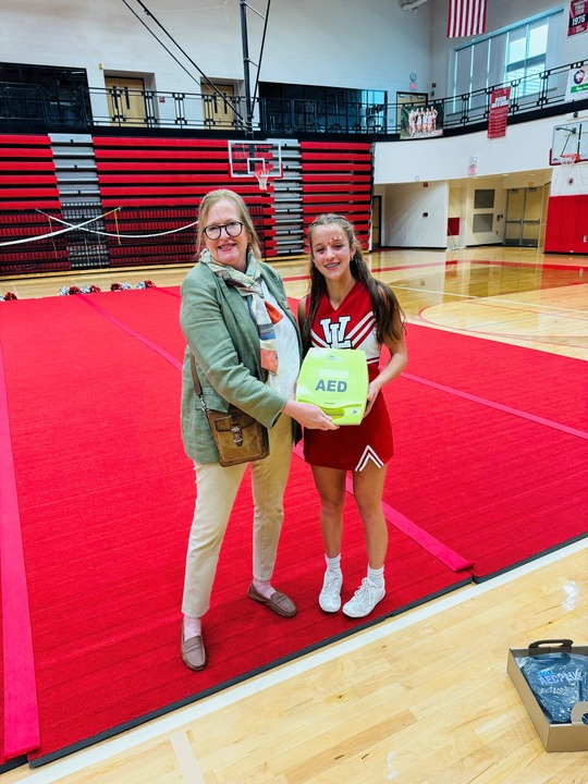 State Rep. Jennifer Conlin delivering an automated external defibrillator to Whitmore Lake High School before the fall Homecoming football game.