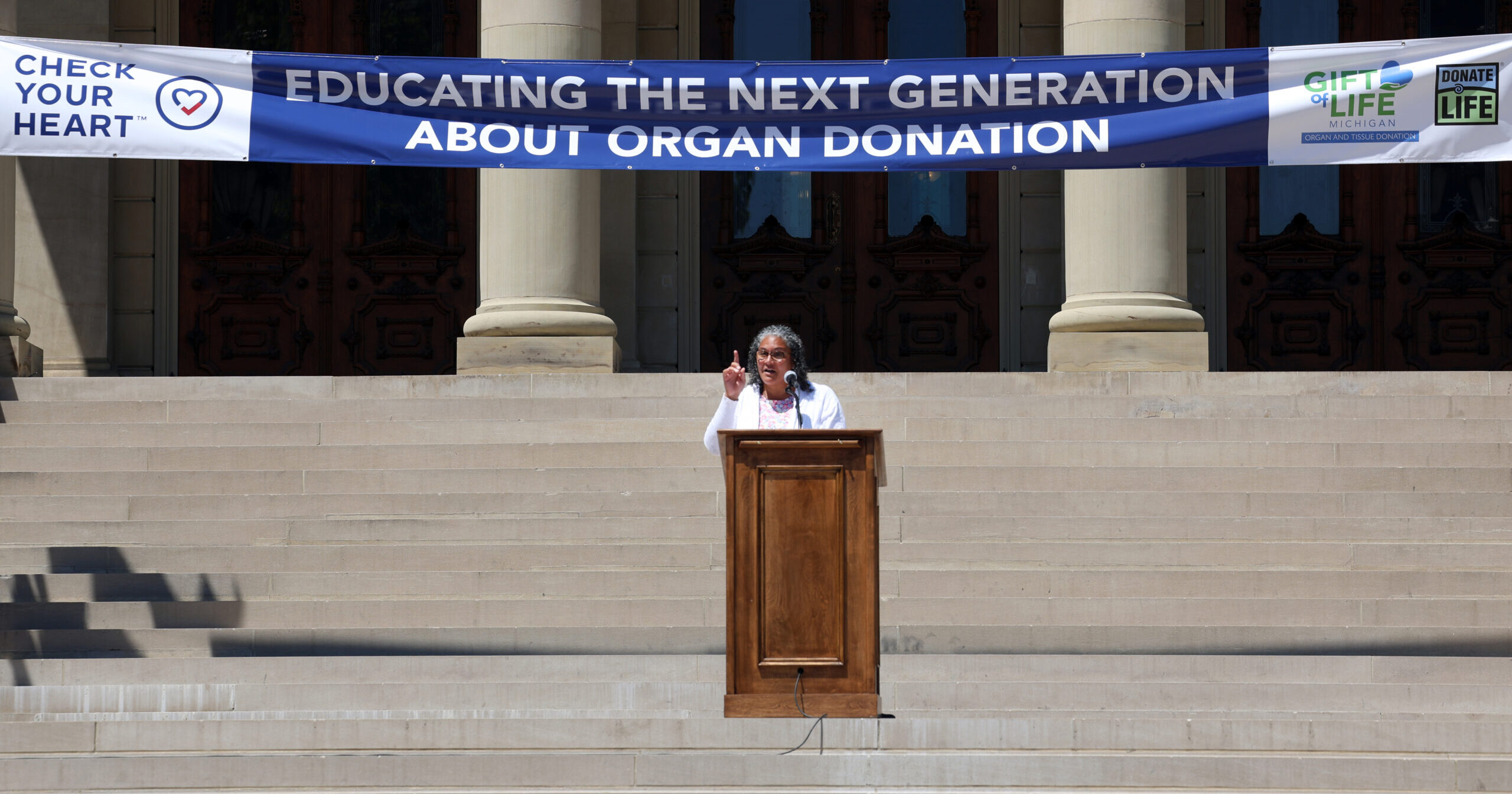 State Rep. Felicia Brabec Speaks on capitol steps at a Check Your Heart event.