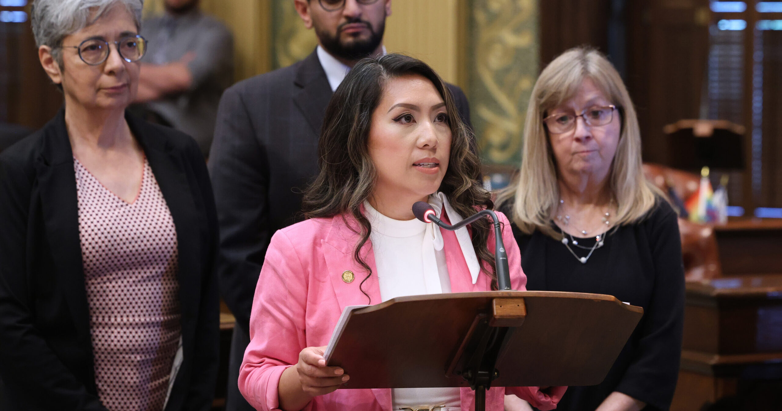 Michigan State Representative Mai Xiong delivers a speech on the House Floor next to her colleagues in the Michigan Capitol Building.