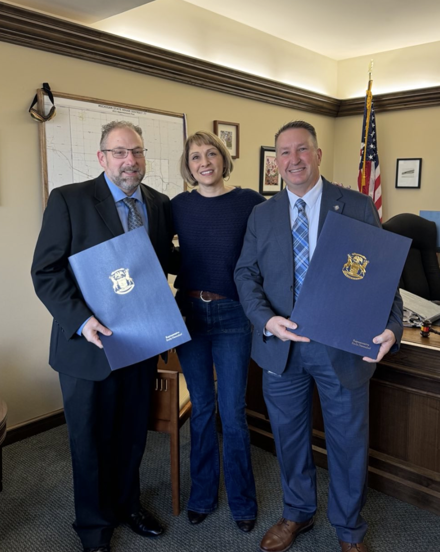 Michigan State Representative Emily Dievendorf stands with two constituents, Michael Wolcott and Jim Flegel. 