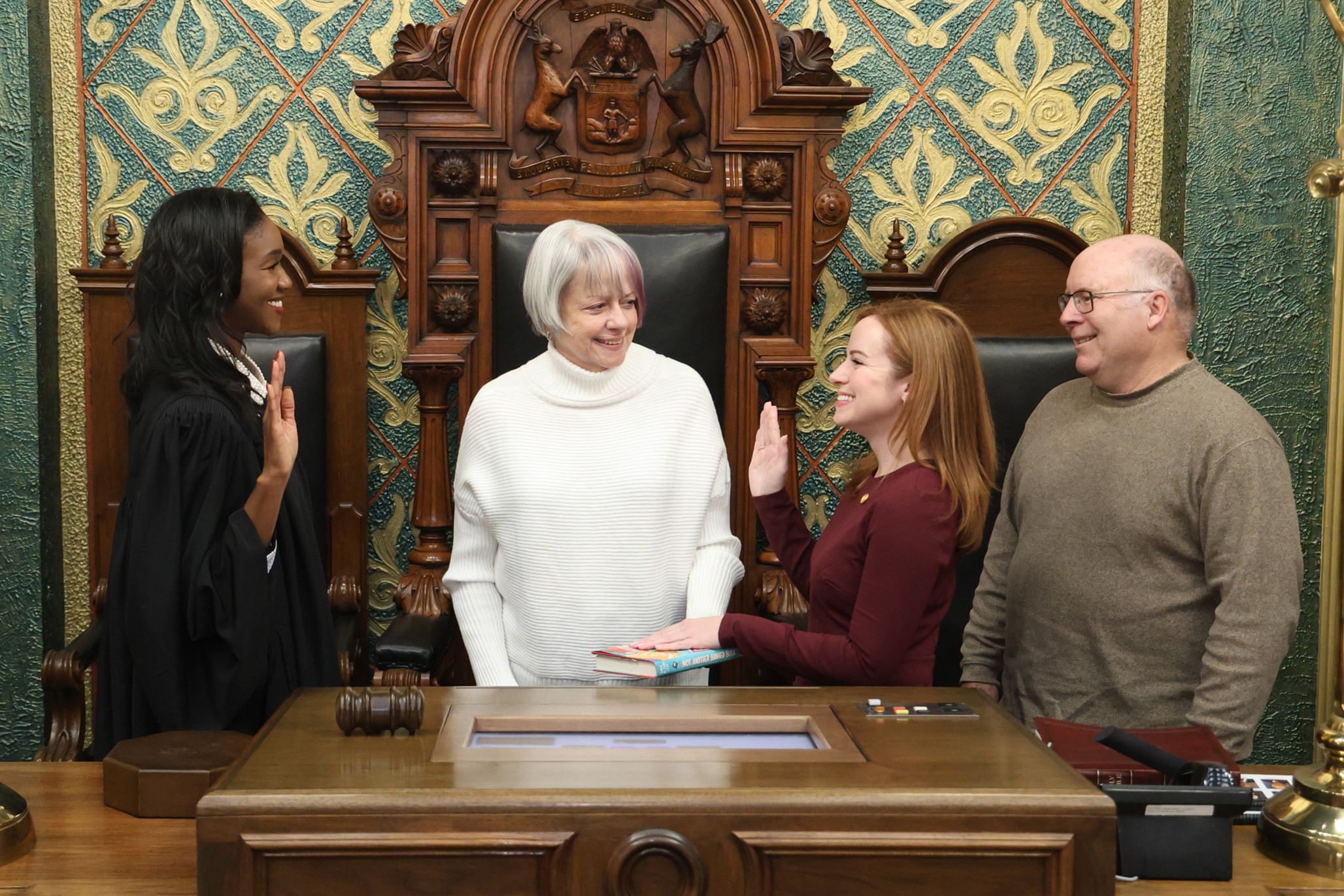 Michigan State Representative Erin Byrnes stands with guests while being sworn into the 103rd Legislature by Michigan Supreme Court Justice Kyra Harris Bolden.