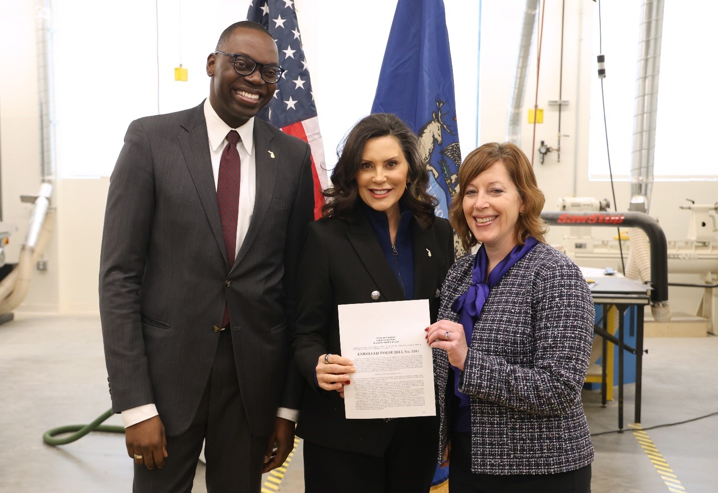 Michigan Lieutenant Governor Garlin Gilchrist, Governor Gretchen Whitmer and State Rep. Julie Rogers stand with Rep. Rogers' research and discovery tax credits bill signed into law.