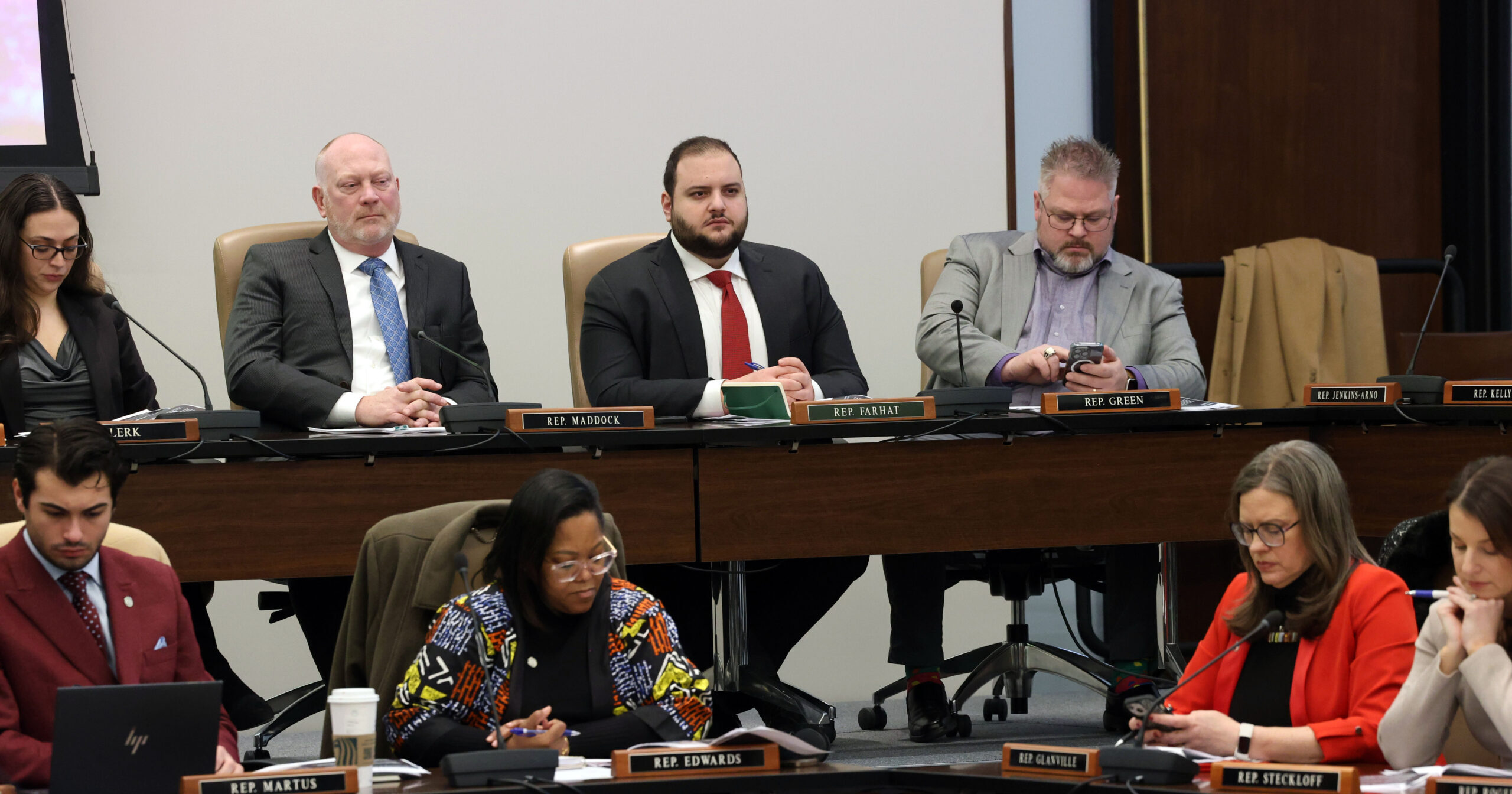 Michigan State Representative Alabas Farhat sitting with colleagues at the governor's budget presenation.