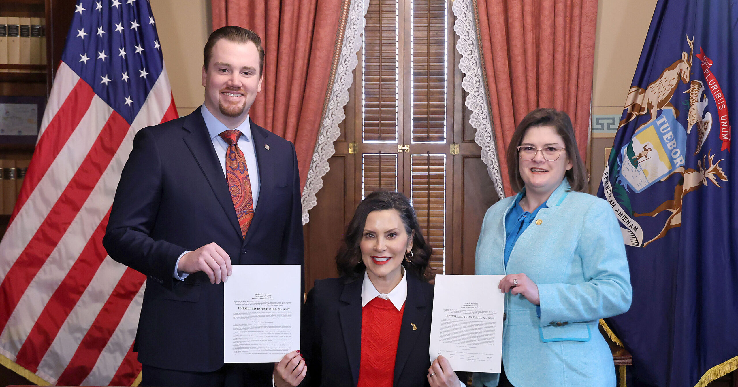 Democratic Floor Leader John Fitzgerald and Michigan State Representative Kara Hope pose for a photo with Michigan Governor Gretchen Whitmer while holding their signed legislation.